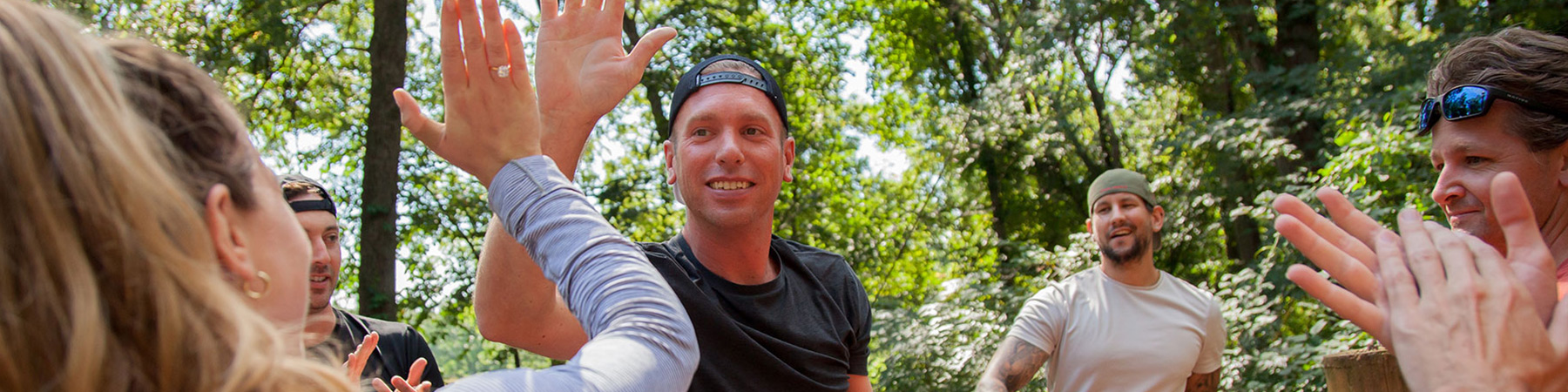 NGLI participant high-fiving a colleage while on the outdoor high-ropes course