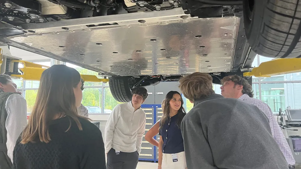Business honors students look under a lifted car in the Volkswagen factory in Chattanooga, Tennessee