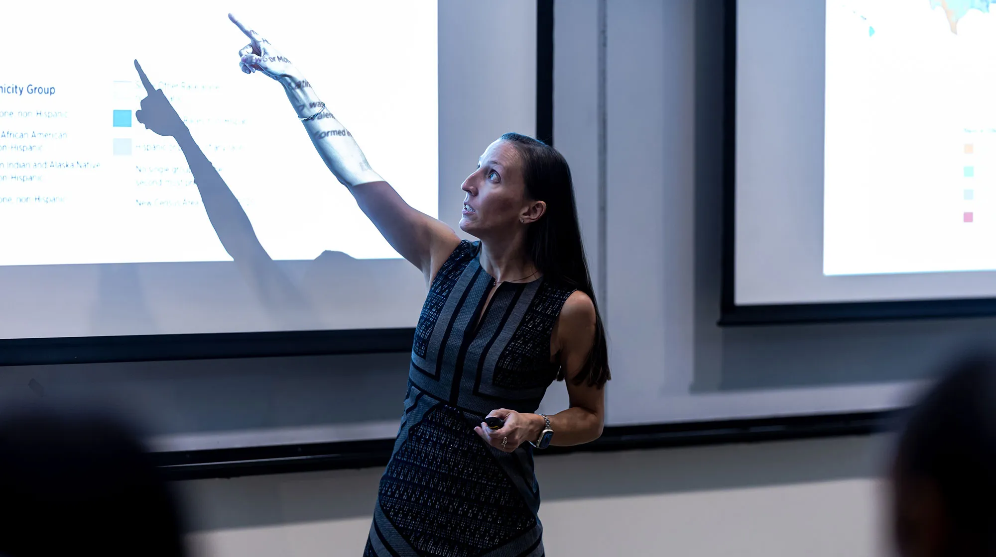 Brittany Bauer points to the projection on the wall in her class as she speaks to the unseen students attending.