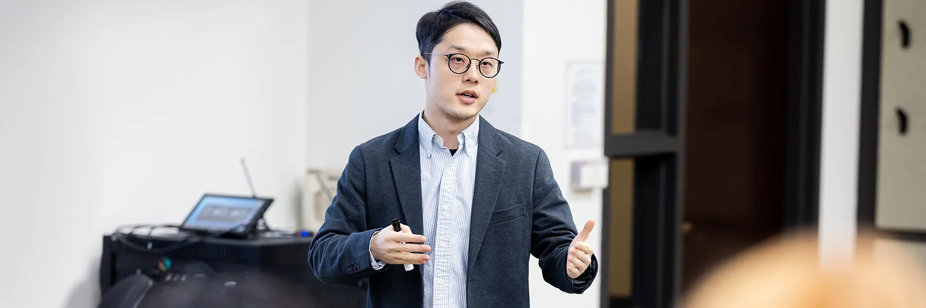 Yuiao Rain Luo teaches in a simple white walled classroom.