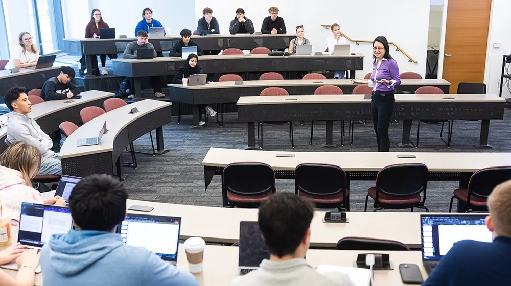 Zongfei Lisa Yang speaks to students as she stands in the center of the classroom floor teaching.