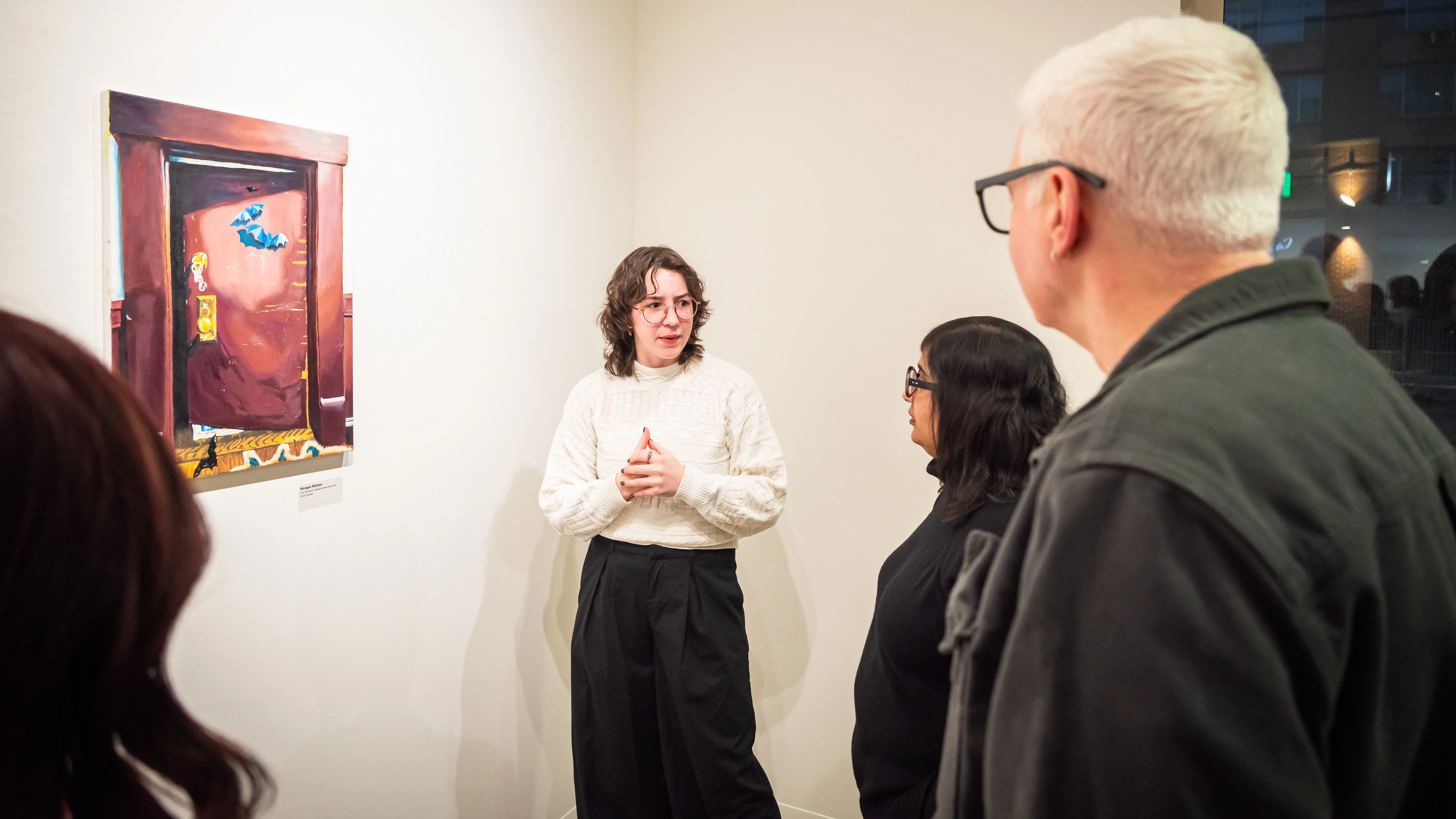 A Loyola Fine Arts student presenting their work in Ralph Arnold Gallery