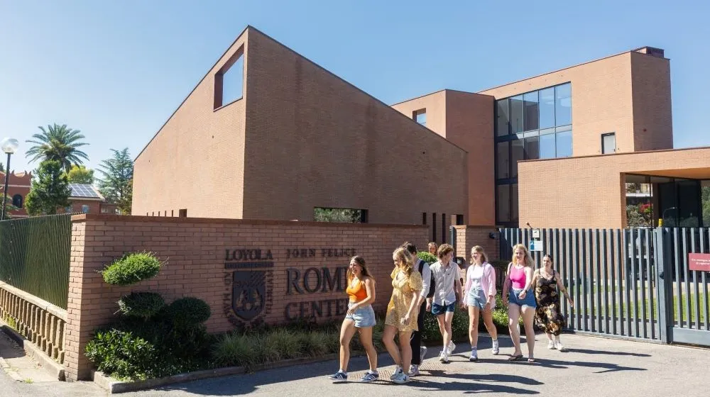Students walk outside on the Loyola Rome campus