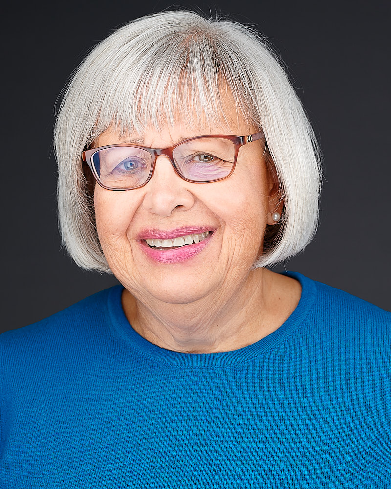 Joanne Kouba smiling in front of a dark background
