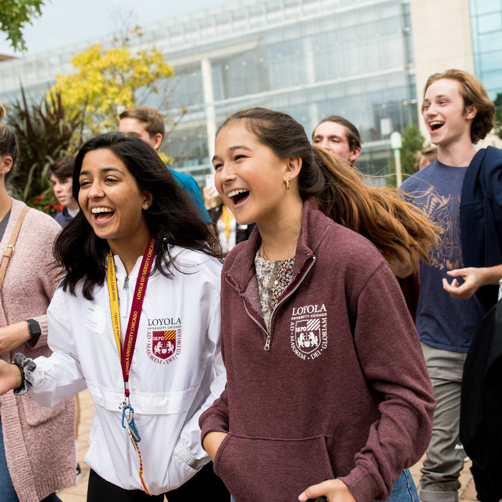 Estudiantes de la Universidad Loyola de Chicago caminando y riendo al aire libre