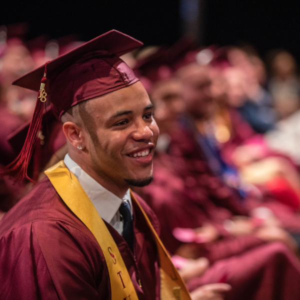 Студент Лойолы улыбается во время церемонии вручения дипломов