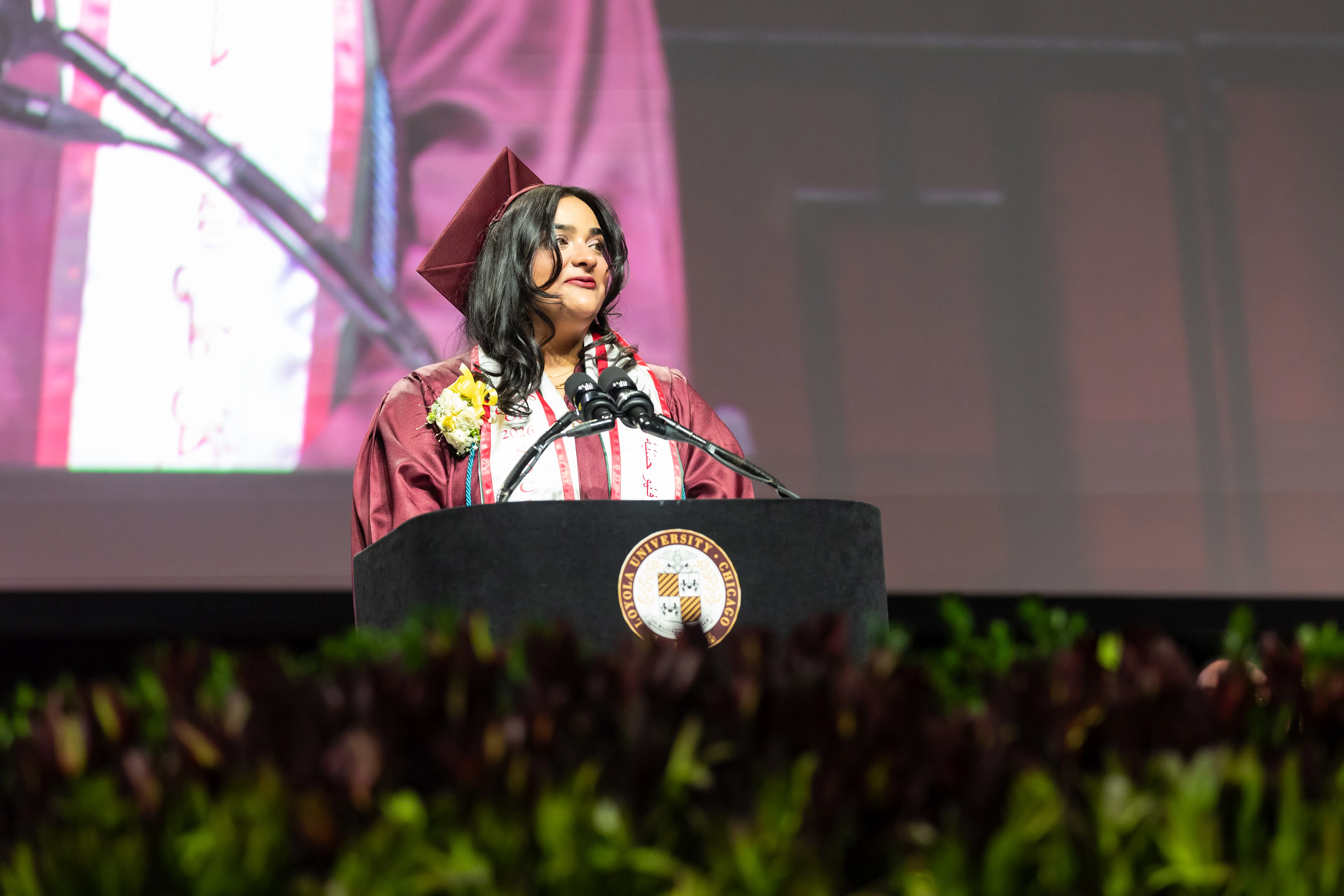 Noor Paracha Hayat speaks at the podium during the 2026 Commencement Ceremony.