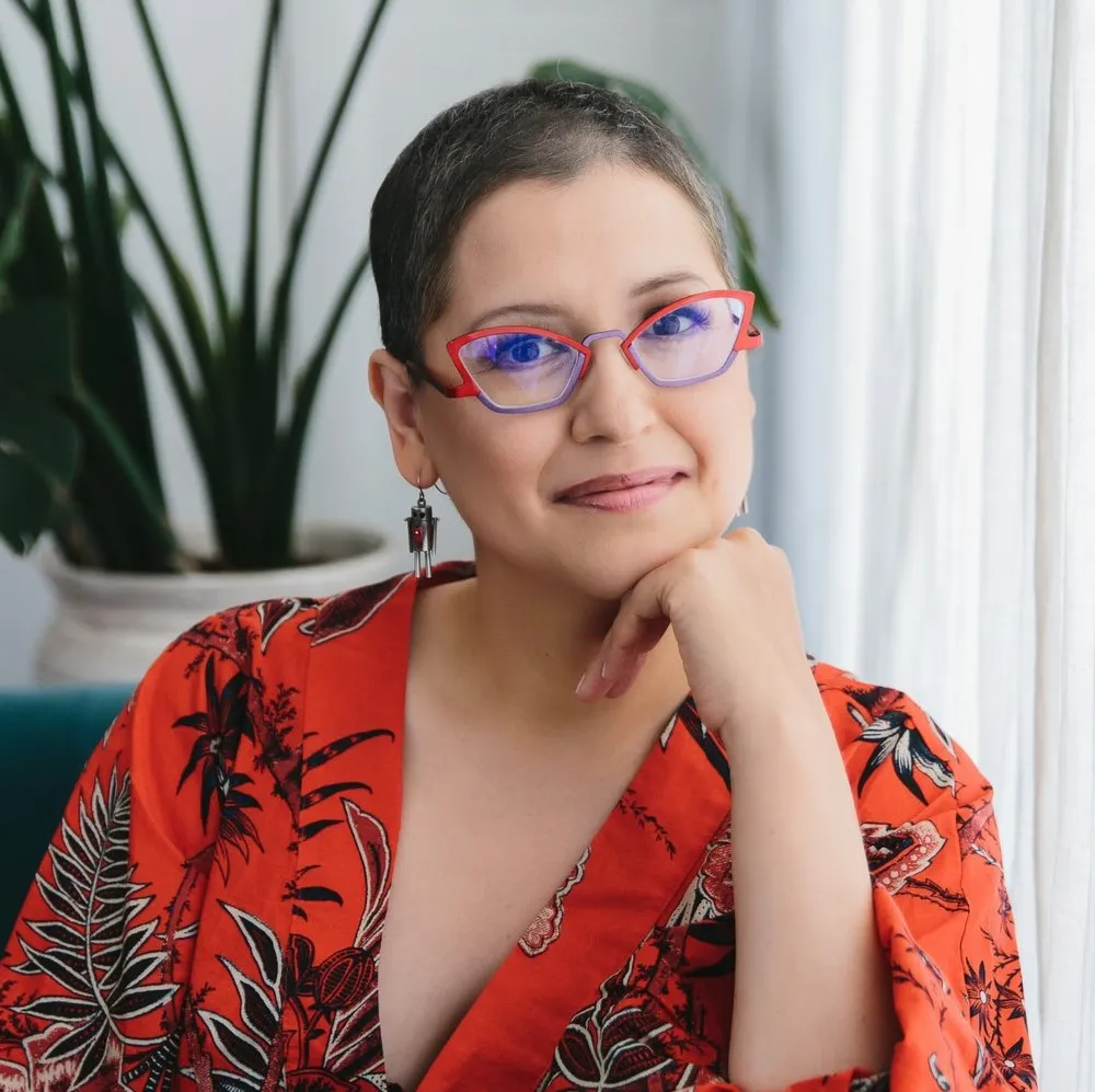 Photo headshot of young female professor with short dark hair and glasses