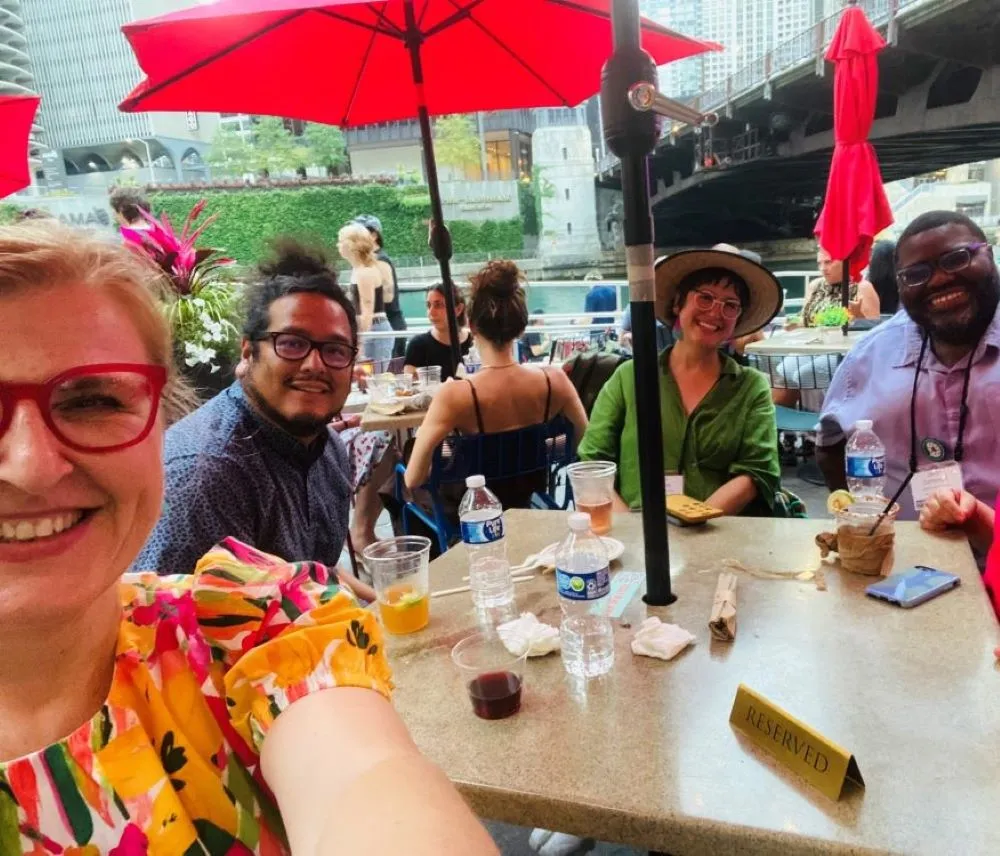 Alma Begicevic, Cristian Paredes, Teresa Gonzales, Jason L. Cummings sitting at a table outside on a sunny afternoon. Alma Begicevic, Cristian Paredes, Teresa Gonzales, Jason L. Cummings sitting at a table outside on a sunny afternoon.
