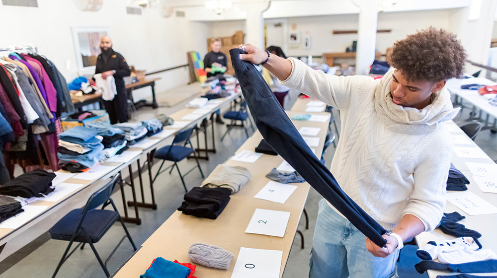 A student folds a pair of pants at the Chicago Lights donation center on MLK Day of Service 2025.