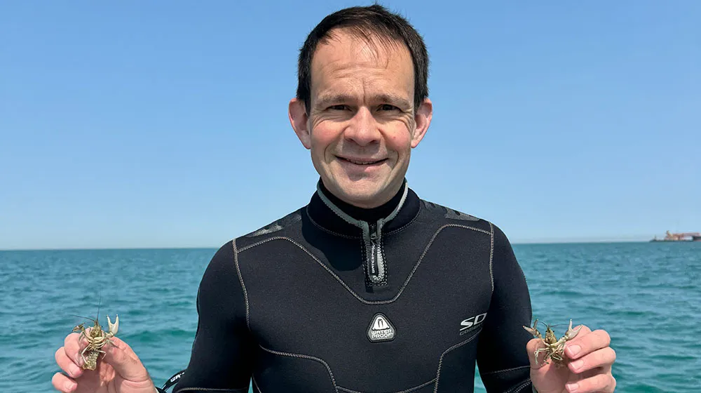 Reuben Keller holding crayfish