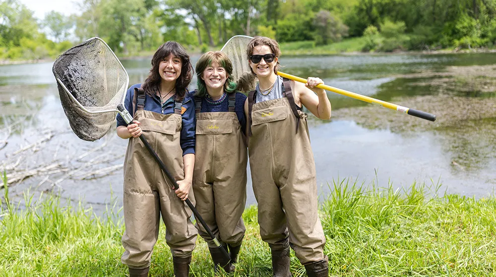 Три студента в галошах улыбаются перед прудом