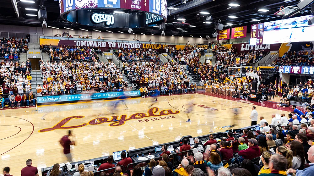 A roaring crowd of Loyola fans in Gentile Arena during a basketball game.