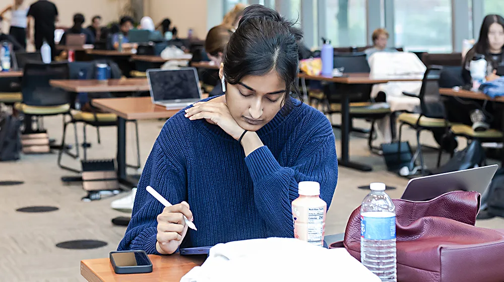 A young woman studies at the Health Sciences campus.