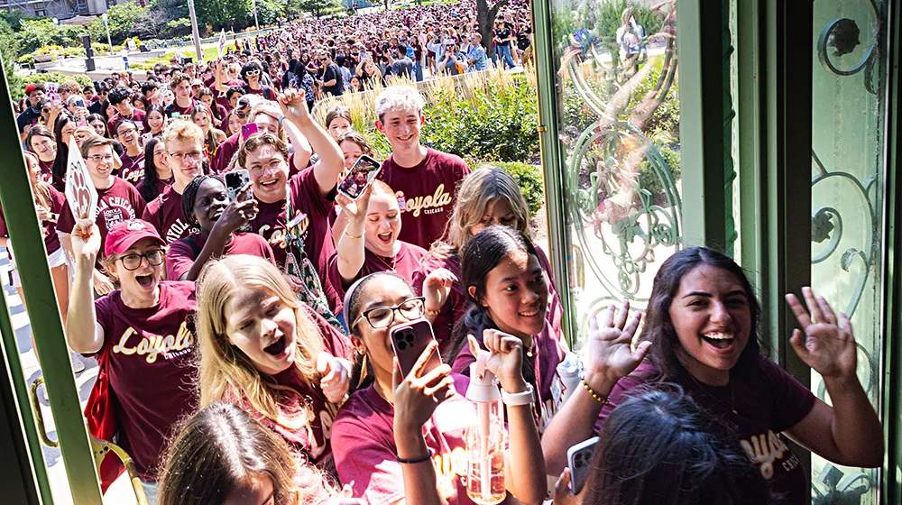 A long-standing tradition, new students line up to walk through the Cudahy Library doors during Welcome Week.