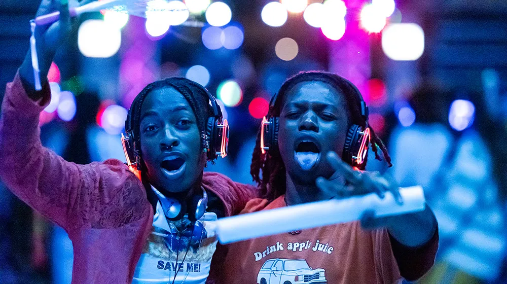 Two friends, arm-in-arm having a fun time at the Silent Disco event on campus during Welcome Week. Two friends, arm-in-arm having a fun time at the Silent Disco event on campus during Welcome Week.