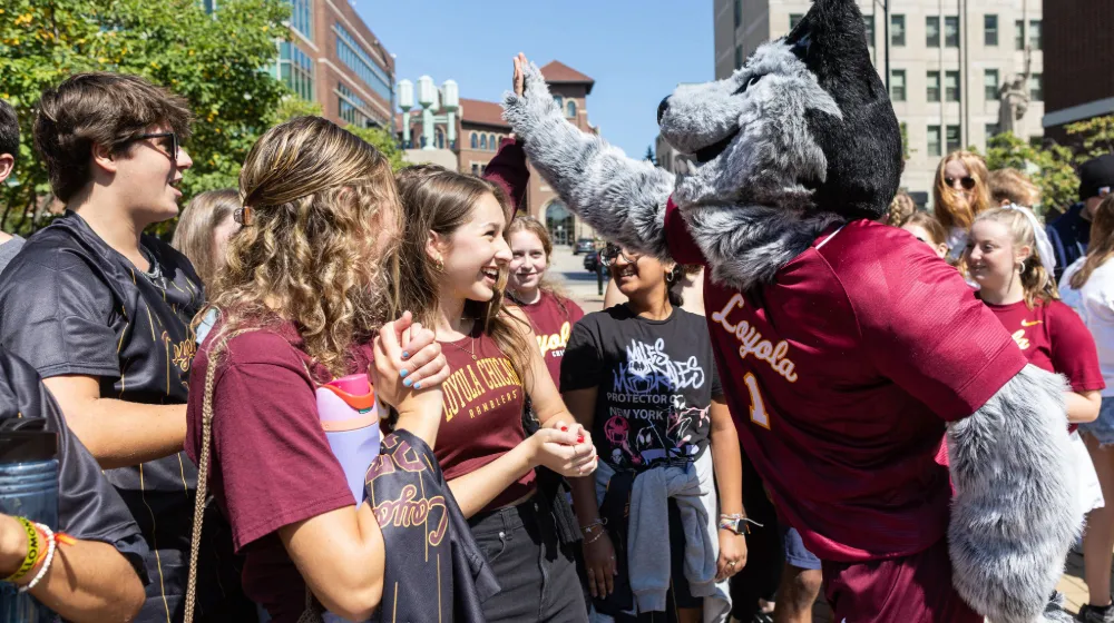 Students meeting Lu Wolf, giving out high fives at the Pep Rally for Hustle to Hoyne.
