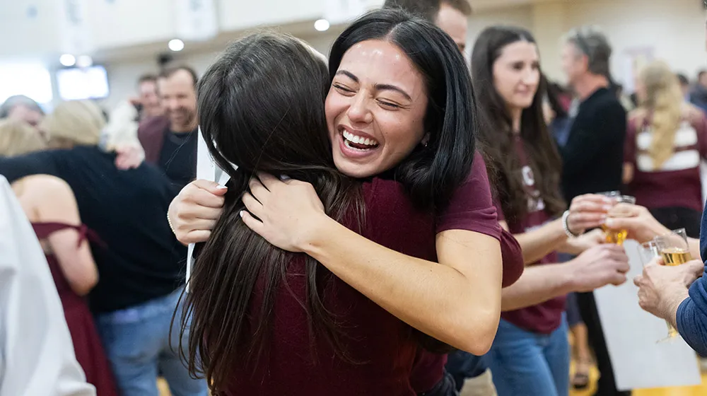 Athena Barrett hugs a classmate at Match Day after learning where she matched for residency