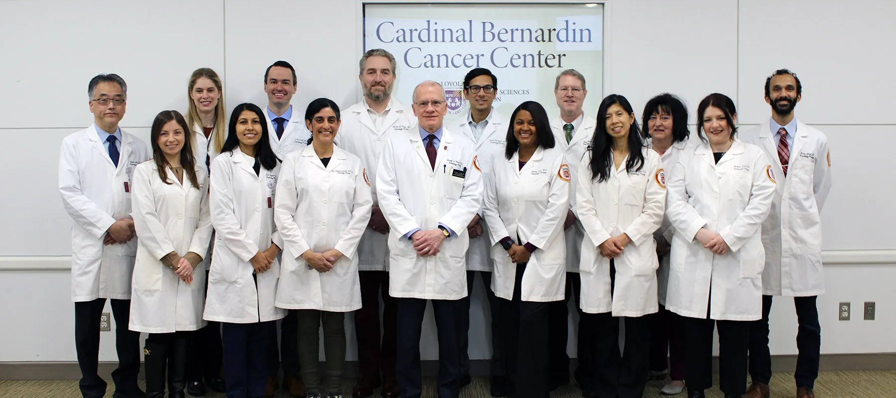 Faculty members wearing white coats in group photo