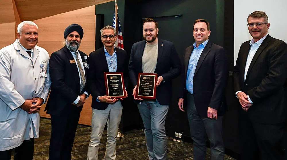 Group photo of University and Stritch leaders with the Senior Scientist (pictured center left) and Junior Scientist (center right) award winners