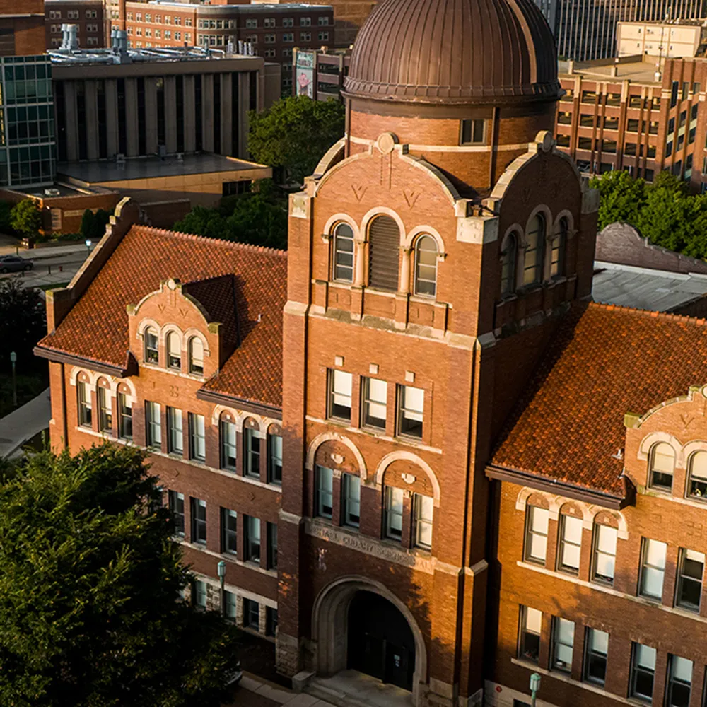 An aerial perspective of the copper-domed Dumbach building at golden hour on the Lake Shore campus of Loyola.