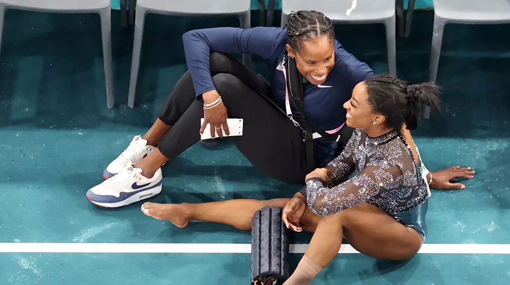 Simone Biles speaks with team physician Dr. Marcia Faustin during women’s gymnastics qualification at the 2024 Paris Olympics