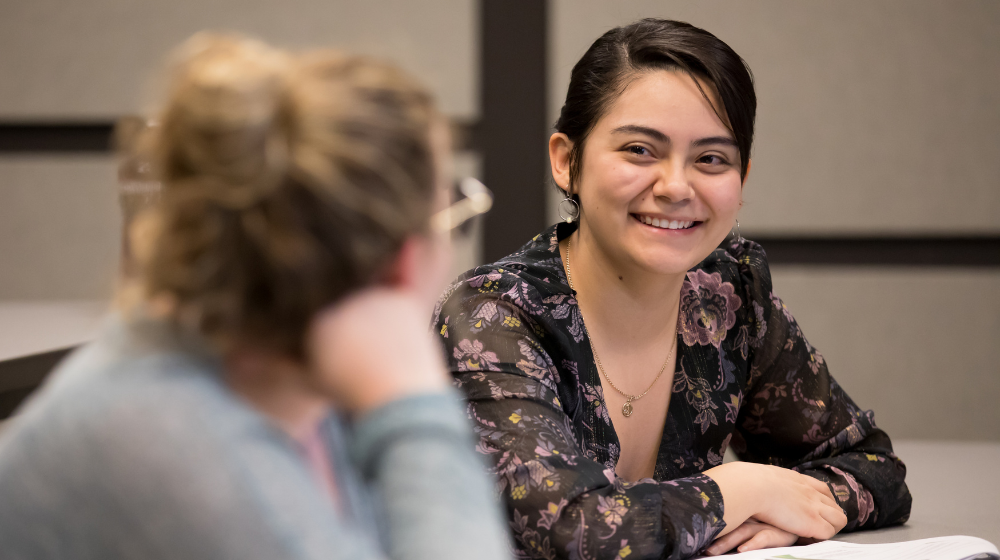 Alumni chat at a professional development workshop on campus.