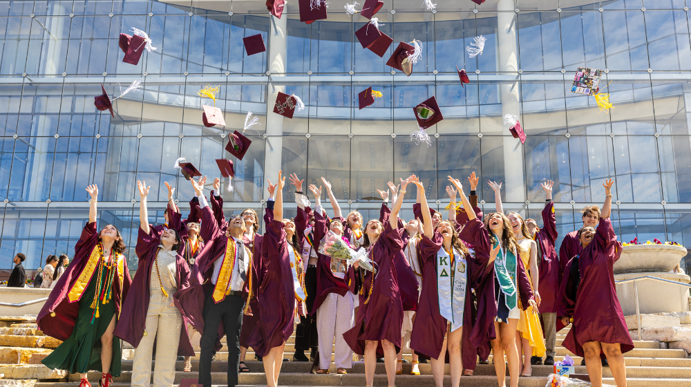 Graduates toss caps into the air during commencement celebration