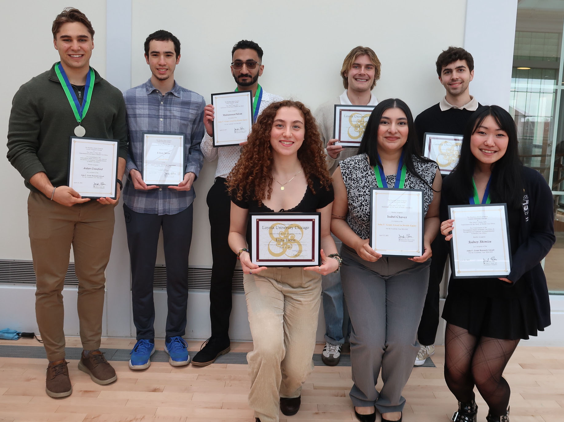 Students holding awards and certificates in a group photo