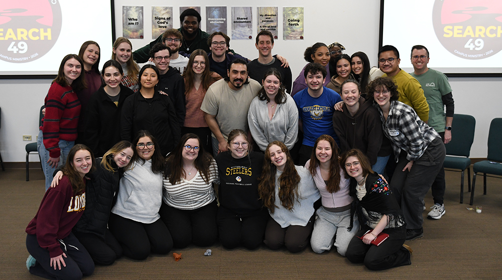Group of students clustered together smiling