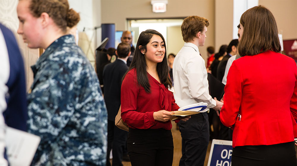 Student speaking with employer at Loyola University Chicago healthcare career and internship fair