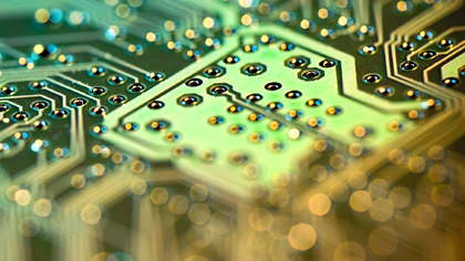 Macro view of a circuit board with gold connections and solder points.