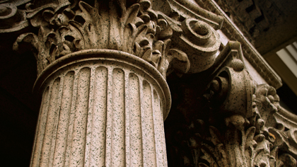 Close-up of an ornate Corinthian column with carved stone details.