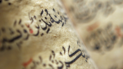 Close-up of Arabic calligraphy on aged parchment manuscript.