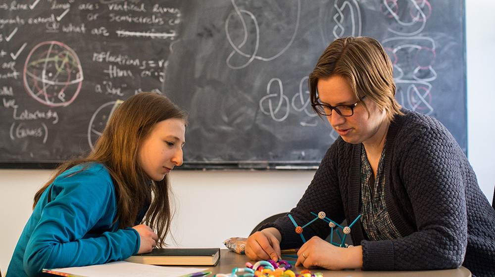 Loyola University Chicago Assistant Professor Emily Peters works with her student, Arianna, on an independent study of knot theory in her office in BV