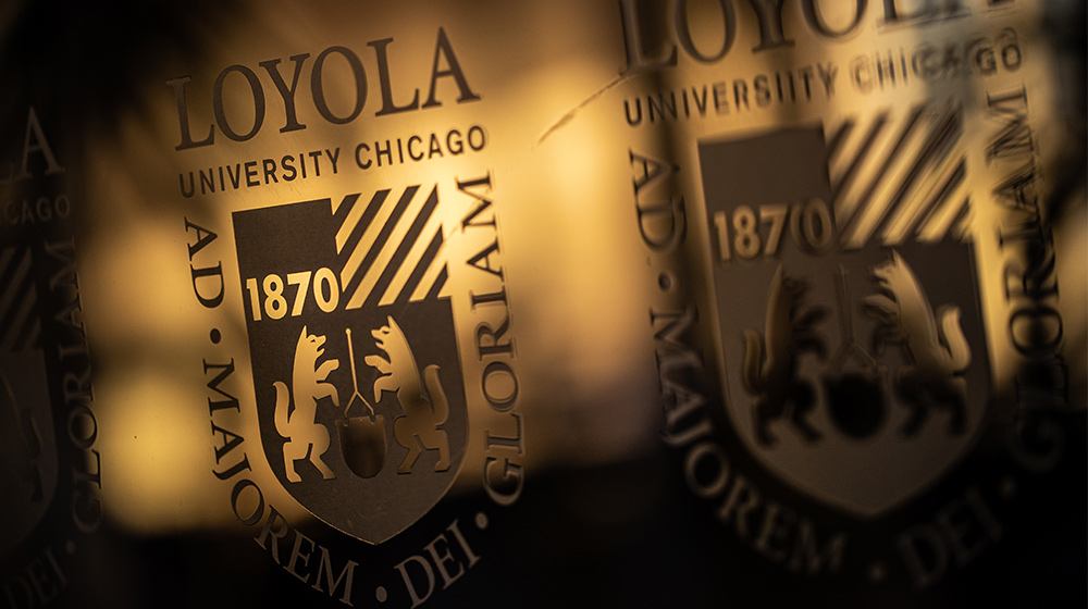Loyola University Chicago seal with the university crest and founding year 1870, shown in a close-up reflection.