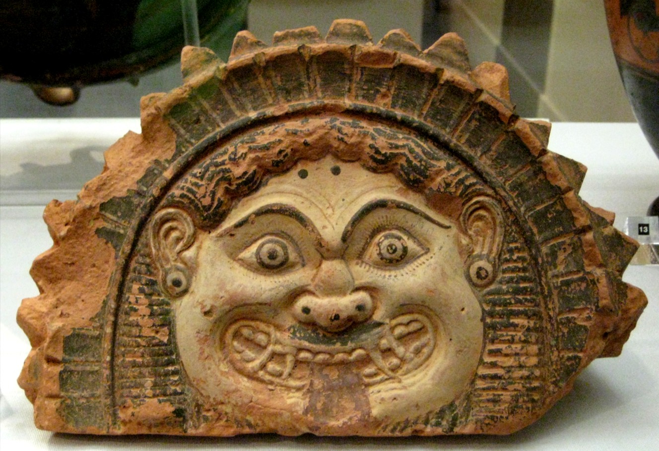 Ancient ceramic artifact featuring a stylized human face with ornate detailing