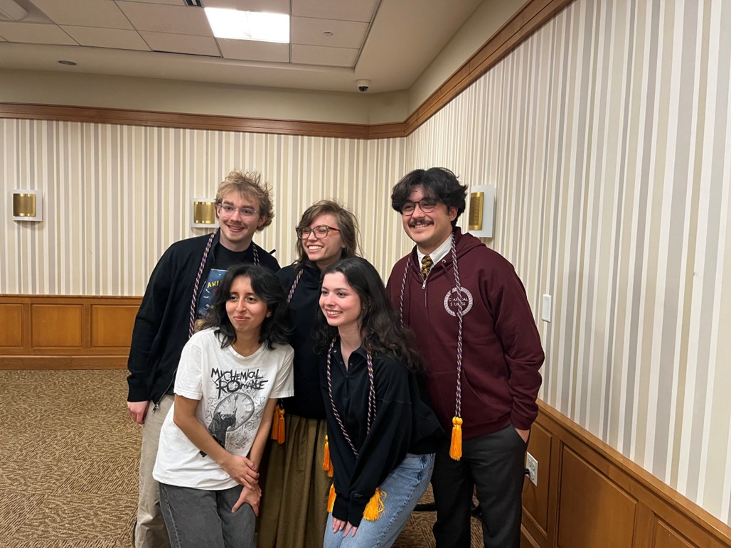 Group of students posing together indoors, wearing honor cords