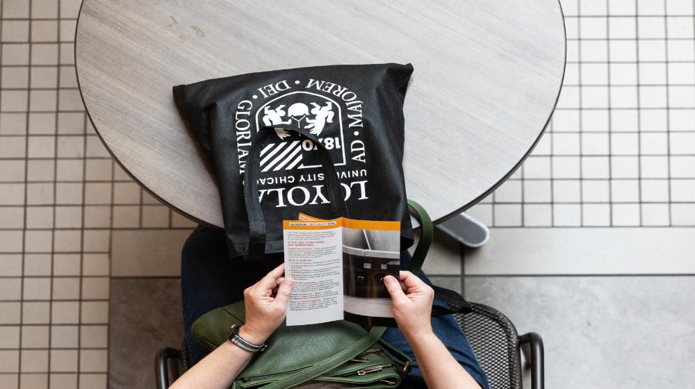 Overhead image of a person holding a brochure via Loyola University Chicago's financial student resources. Overhead image of a person holding a brochure via Loyola University Chicago's financial student resources.