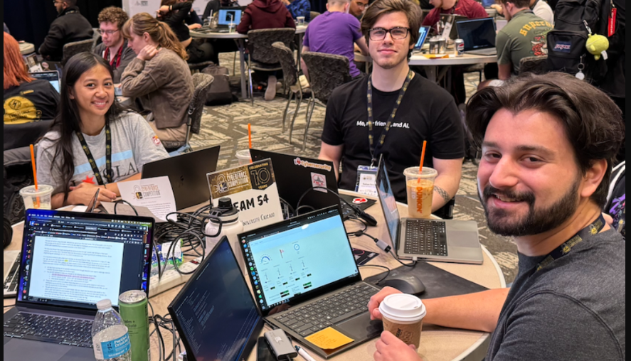 Group of students working together on laptops at a collaborative event