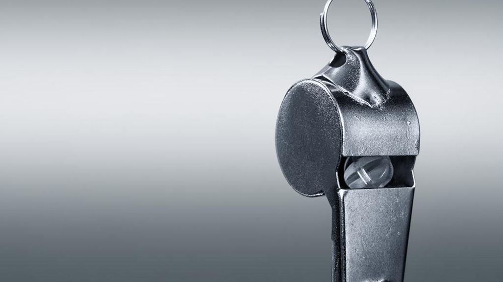 Close shot of a silver sports whistle hanging facedown, symbolizing the Loyola University Chicago Ethics hotline.