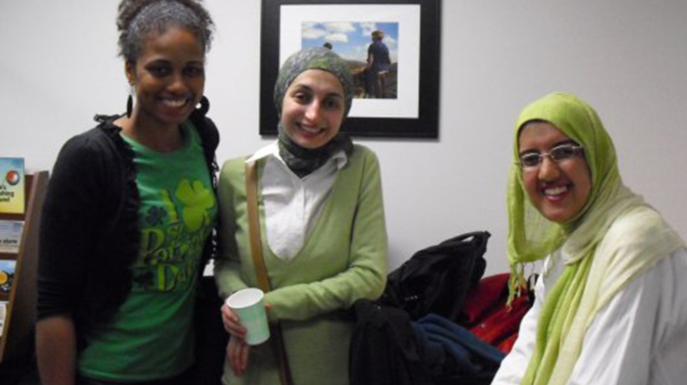 Multiple ESL students wearing shades of green pose for a group photo