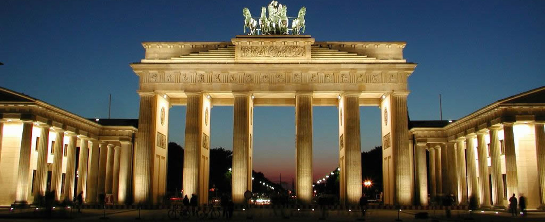 The Brandenburg Gate, lit up at night, in Berlin, Germany. This renowned landmark is a symbol of German reunification and is studied by German students at Loyola University Chicago.
