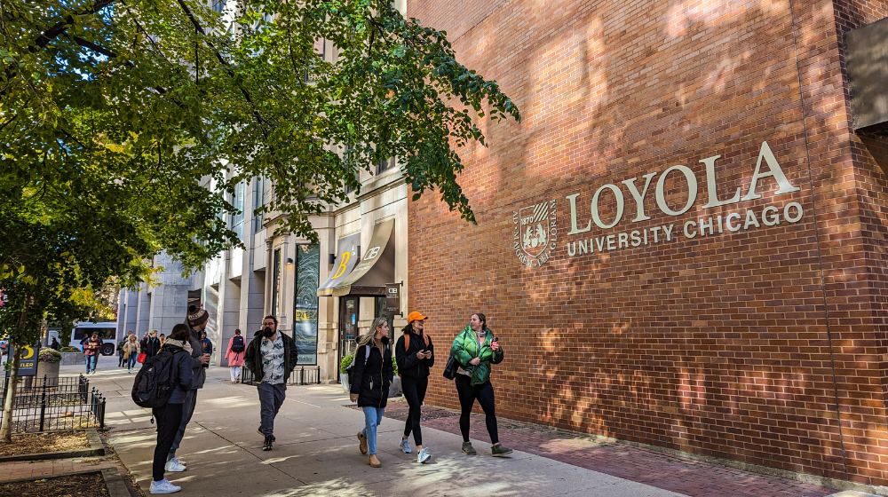 Student walk past the Arrupe College building on the Water Tower Campus.