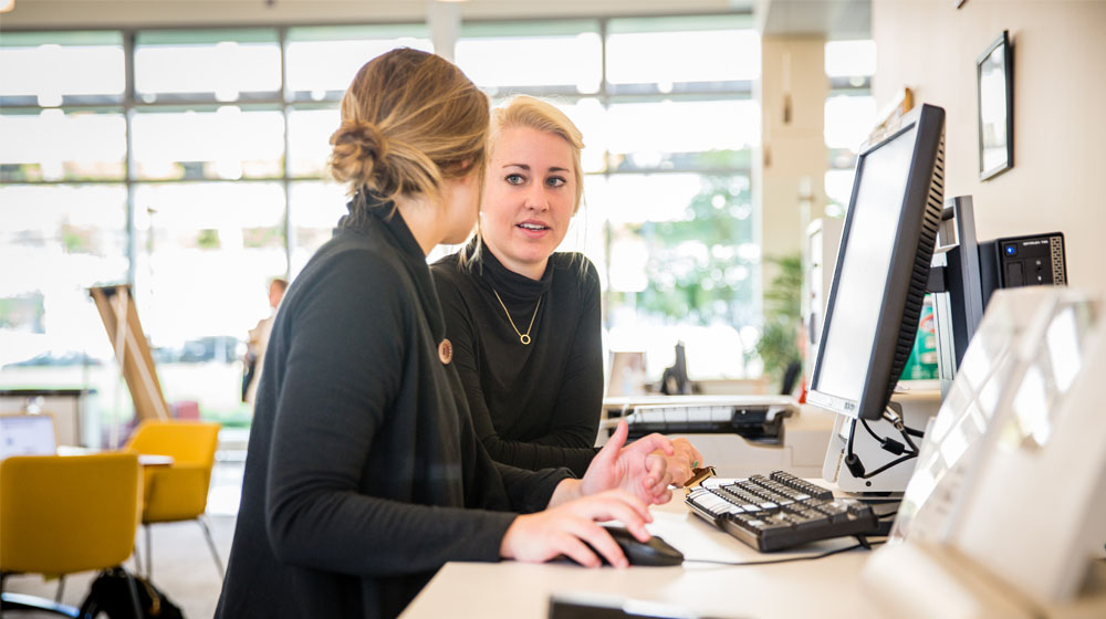 Loyola University Chicago students meet with a librarian for research assistance in the Information Commons