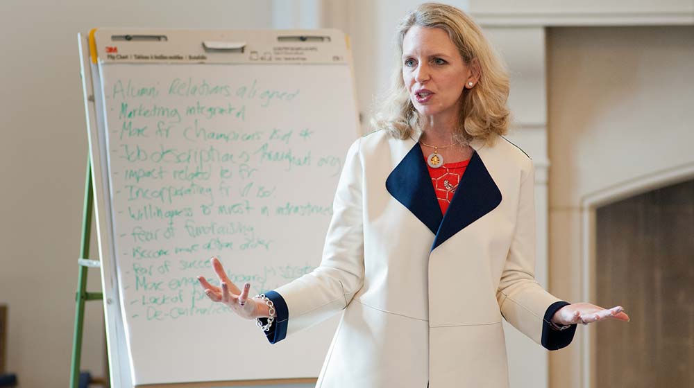 Woman speaking and gesturing during a presentation in front of a flip chart
