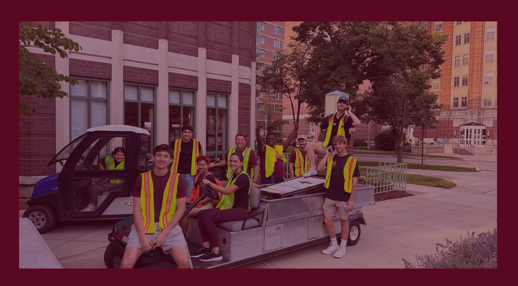 Loyola University Chicago students working on campus facilities tasks pose together outdoors wearing safety vests