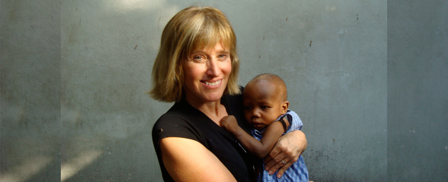 Distinguished alumna, Marie Ginther, holding small baby. 