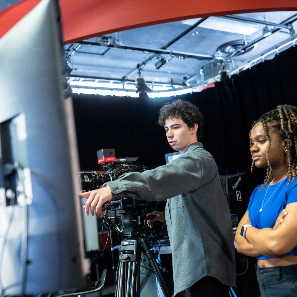 Students operating a camera in a media studio