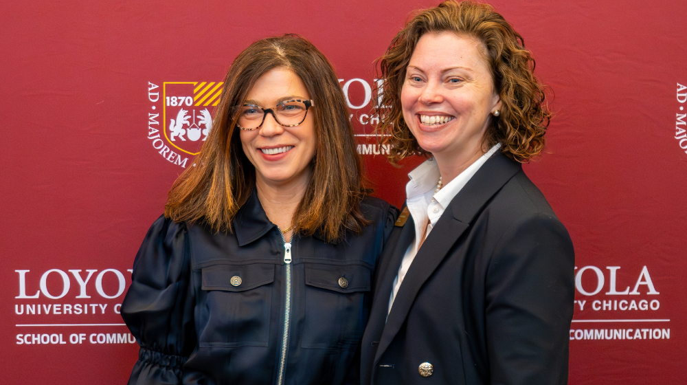 Assistant Dean Ashley Gisger smiles next to graduate student